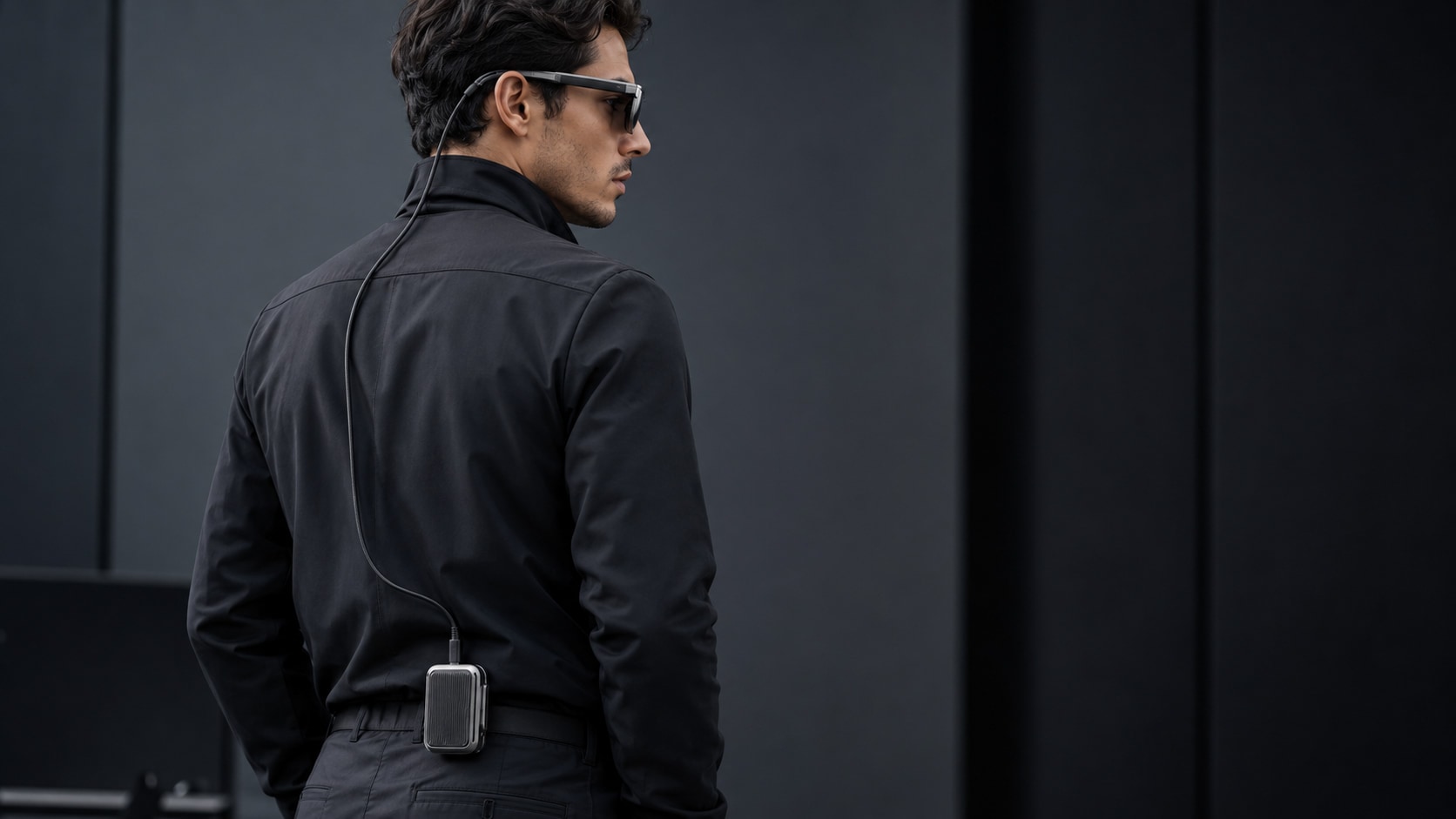RM Core clipped to the back of a belt, tether routed discreetly up the back to VibraRays One